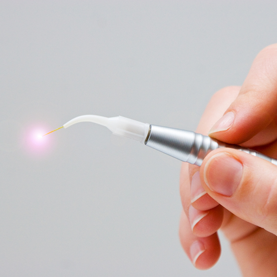 Hand holding a thin pen like dental laser device