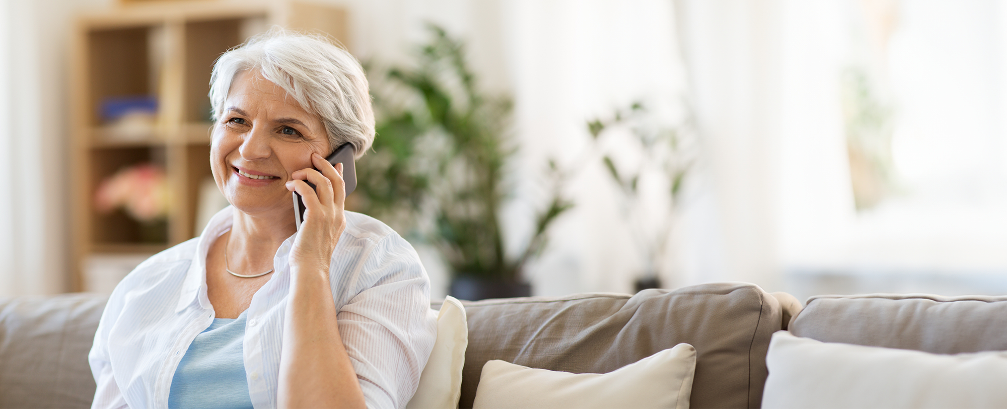 Smiling senior woman talking on the phone with lip and tongue tie dental office in Boulder