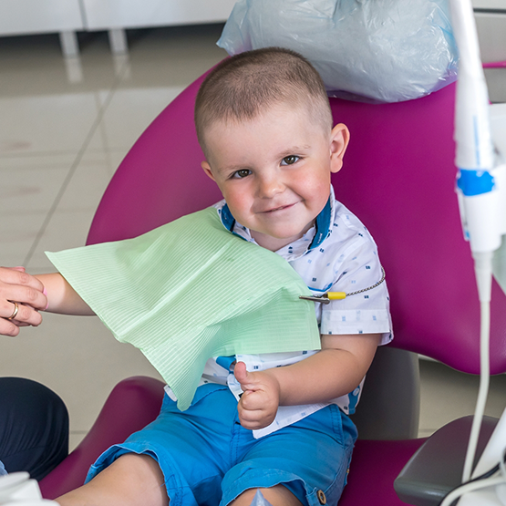 Toddler boy smiling in dental chair