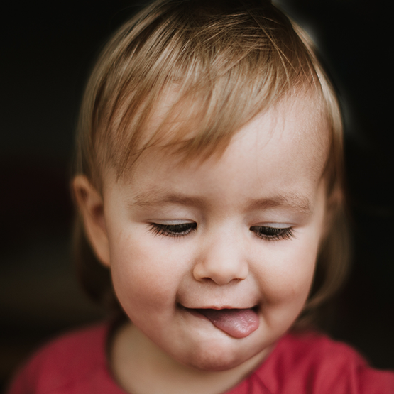 Young child sticking their tongue out to the side