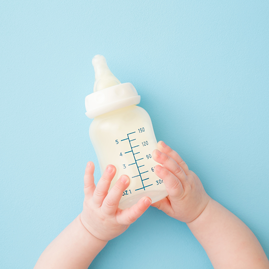 Baby holding a bottle of formula