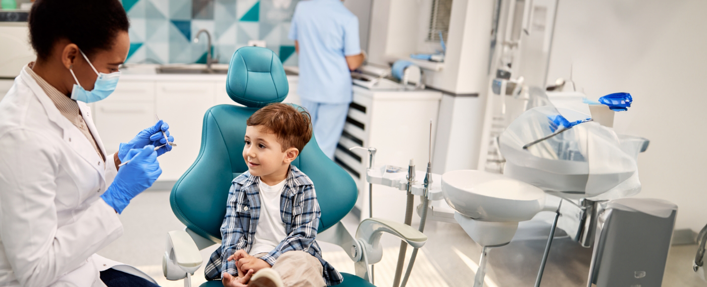 Pediatric dentist smiling at a child patient before a laser frenectomy in Boulder