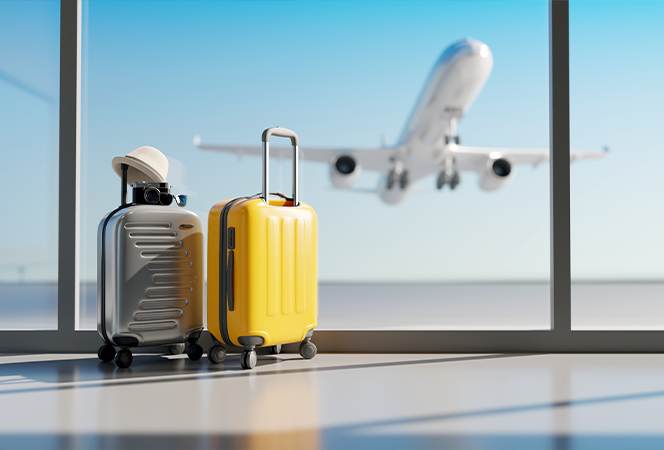 Two suitcases in front of window at airport