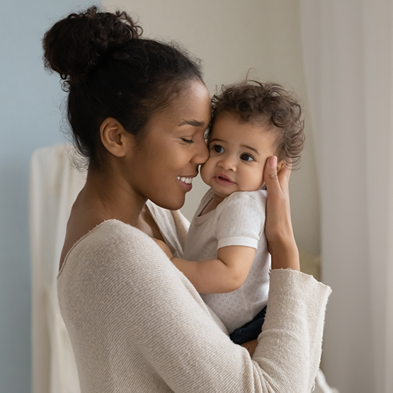 Smiling mother holding her baby close